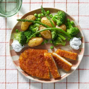 Gepaneerde schnitzel met paddenstoelen, ui, groene groenten